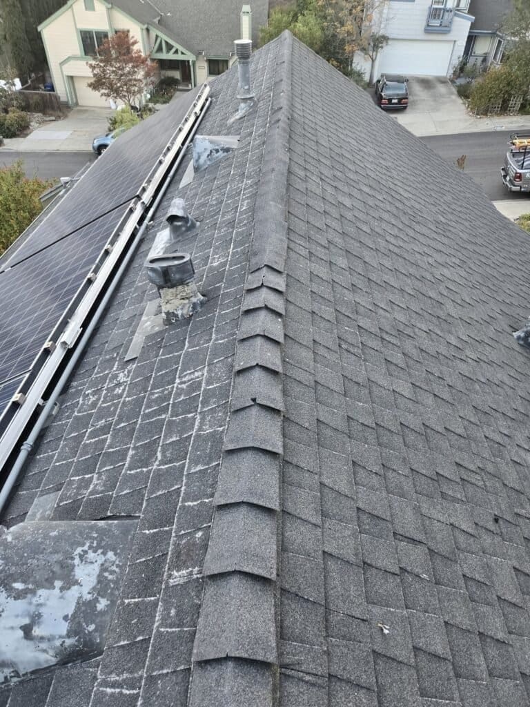 Asphalt shingle roof in Spring Valley, County of San Diego. Asphalt shingles show signs of wear, the fiberglass is showing, mineral is falling off of the shingles, and there are a couple of leaks inside.
