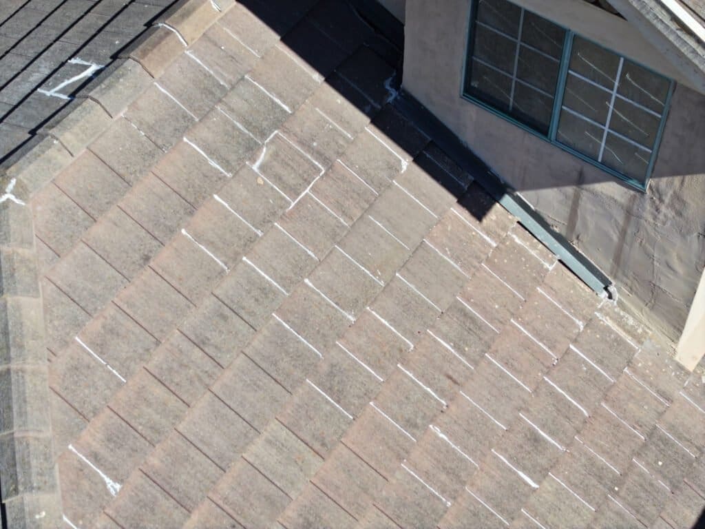 San Diego roof inspection shows attempts to fix roof leak. The tiles are sealed together with a light colored caulking.